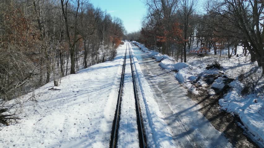 Railroad Tracks through Snowy Minnesota Forest in the Winter