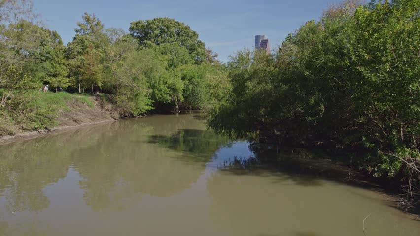 Reveal of Houston skyline from Buffalo Bayou Park river on a sunny day