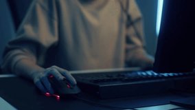 Close up of Woman Gamer Hands using computer mouse and typing, pushing keyboard button playing game. Asian Gamer Girl playing video game at night in Neon Led Light room.