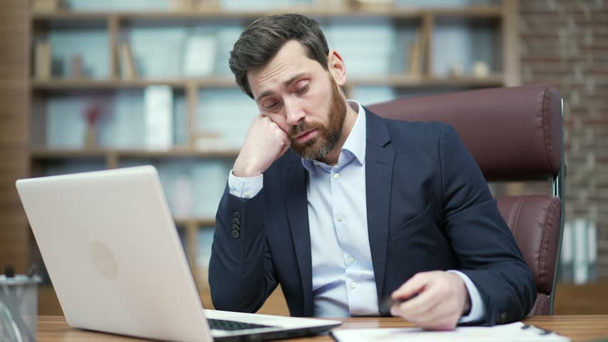 Boring lazy business man employee having long day working on computer with lack of motivation in modern workplace Tired bearded entrepreneur has problems with concentration at desk Procrastination Royalty-Free Stock Footage #1100419845