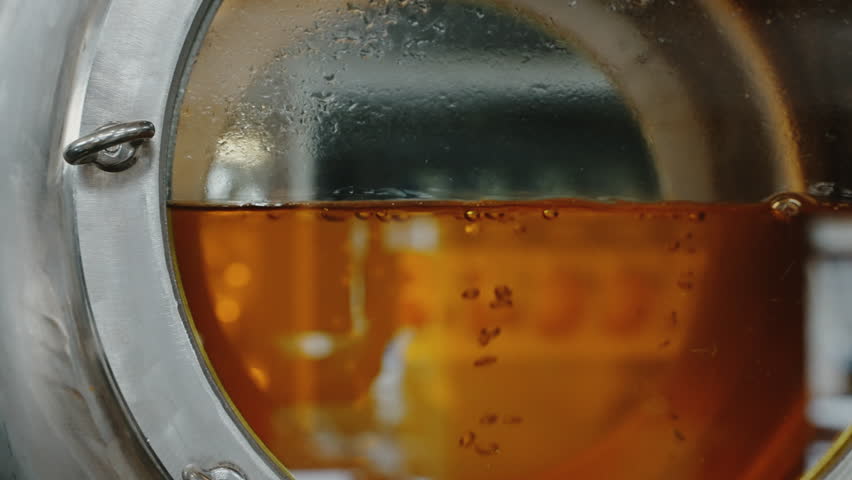 modern brewery, wort is brewing in tank, closeup view, producing of craft and traditional kinds of beers, light lager and ale