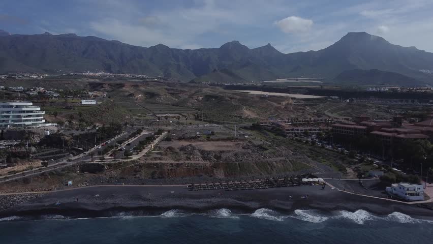 Costa Adeje, Tenerife Island, Spain. Aerial View of Resort Town and Black Sand Beach on Sunny Day, Drone Shot