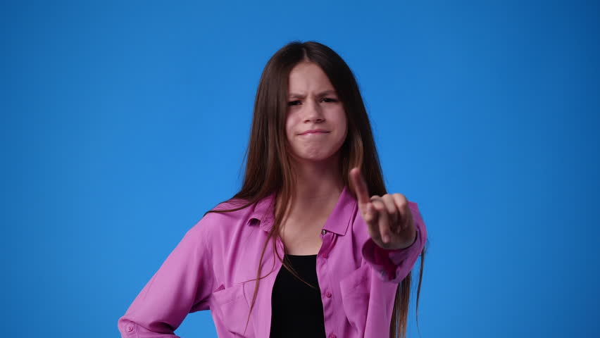 4k slow motion video of one girl who responds negatively to something over blue background. | Shutterstock HD Video #1100432515