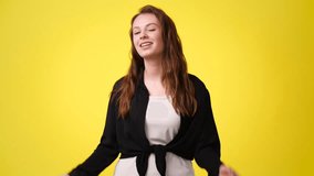 4k video of one girl pointing at camera and showing thumbs up over yellow background.