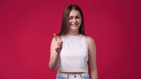 4k video of cute girl waving hello on red background.