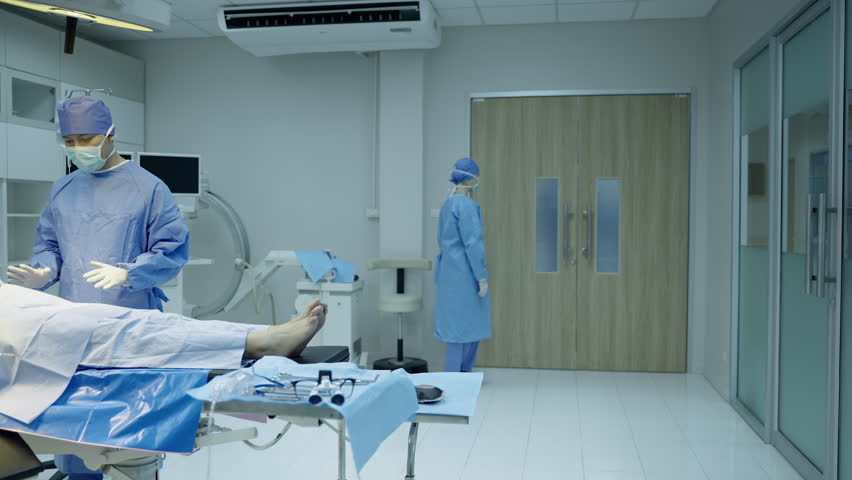 The head of the surgical team was walking hurriedly into the operating room to help an emergency patient. | Shutterstock HD Video #1100434529
