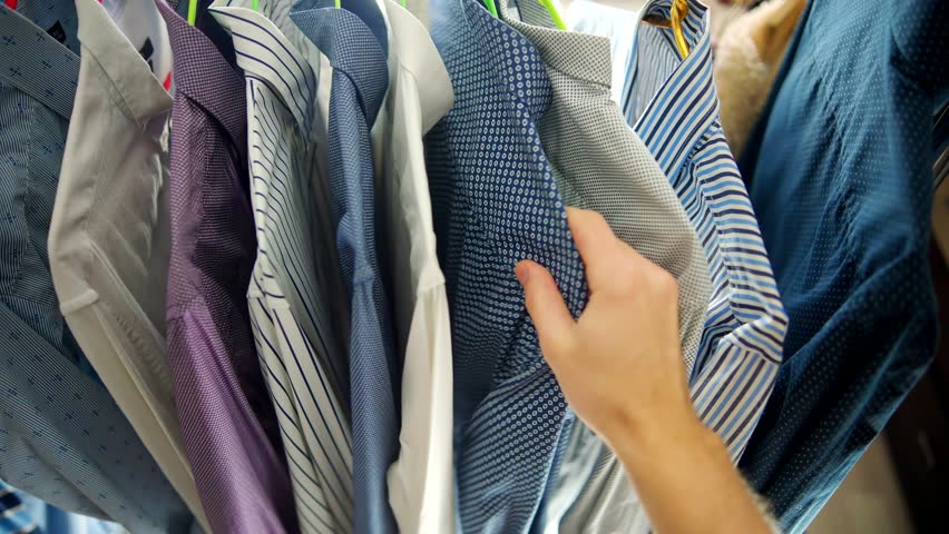 Choose Shirt On Wardrobe Hanger. Garments On Clothes Rack Wardrobe. Plucked Hanger With Clothes.Customer Choice Garment Rack With Shirt.Clothes Hanger Man Shirt. Apparel Consumerism. Dressing Wardrobe | Shutterstock HD Video #1100435157