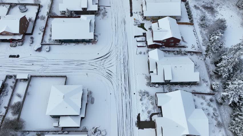 Overhead view of a residential street covered in a sheet of fresh snow.