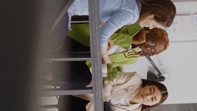 Vertical video: Diverse coworkers analyzing statistics on papers and pc screen, showing executive data report in briefing meeting. People doing teamwork discussing about new development strategy - Powered by Shutterstock - Get 15% off with code: PIKWIZARD15