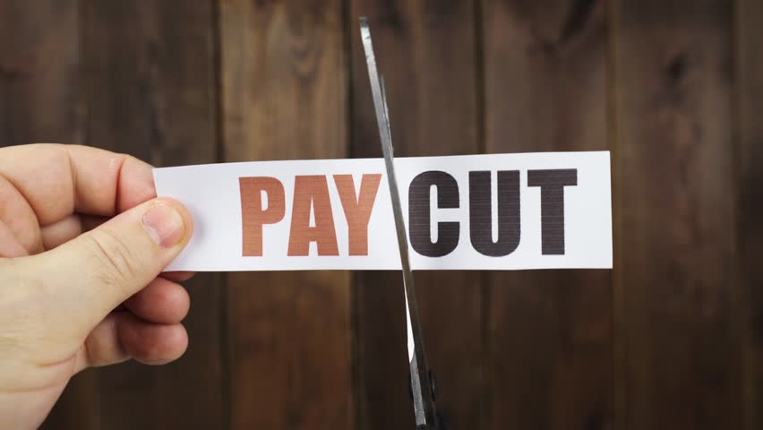 A man cuts with scissors a strip of paper with the inscription - PAY CUT. Royalty-Free Stock Footage #1100446711