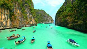 Amazing scenery from drones flying over tropical seas, limestone cliffs and clear blue waters, tour boats and long-tail boat. The best snorkeling and coral reefs in the world. Krabi, Thailand. 4K UHD
