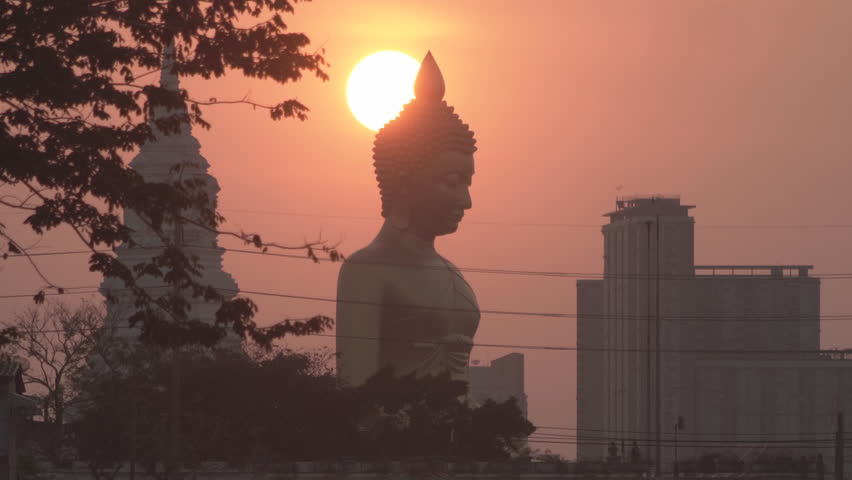Evening sunset timelapse behind the Giant Buddha Statue at Wat Paknam Phasi Charoen in Bangkok, Thailand.