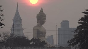Evening sunset timelapse behind the Giant Buddha Statue at Wat Paknam Phasi Charoen in Bangkok, Thailand.