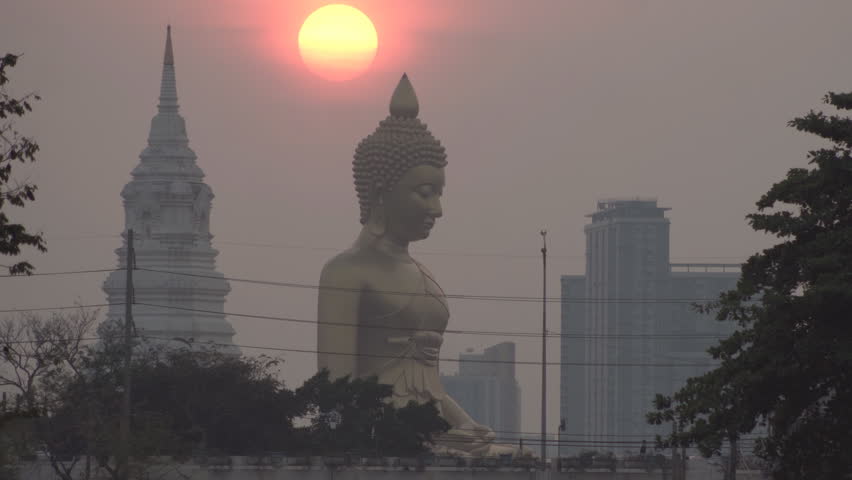 Evening sunset timelapse behind the Giant Buddha Statue at Wat Paknam Phasi Charoen in Bangkok, Thailand.