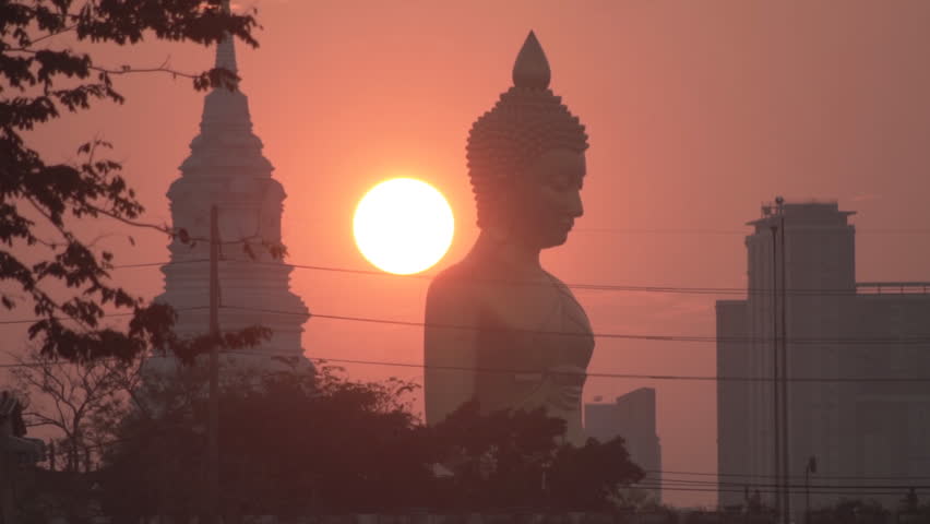 Evening sunset behind the Giant Buddha Statue at Wat Paknam Phasi Charoen in Bangkok, Thailand.