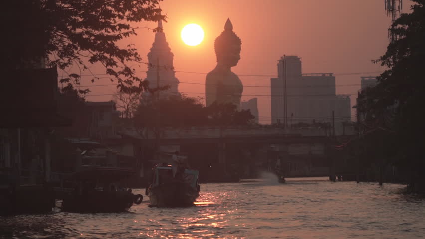 Evening sunset behind the Giant Buddha Statue at Wat Paknam Phasi Charoen in Bangkok, Thailand.
