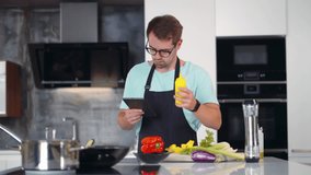 Man check recipe on tablet cooking dinner. Guy with online recipe make meal in kitchen. Male watch tutorial and cook food. Realtime.  - Powered by Shutterstock - Get 15% off with code: PIKWIZARD15