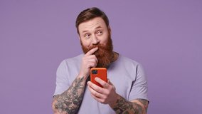 Dreamful pensive minded smiling happy young man 30s wear casual clothes hold use mobile cell phone typing browsing chatting send sms isolated on plain pastel light purple background studio portrait - Powered by Shutterstock - Get 15% off with code: PIKWIZARD15