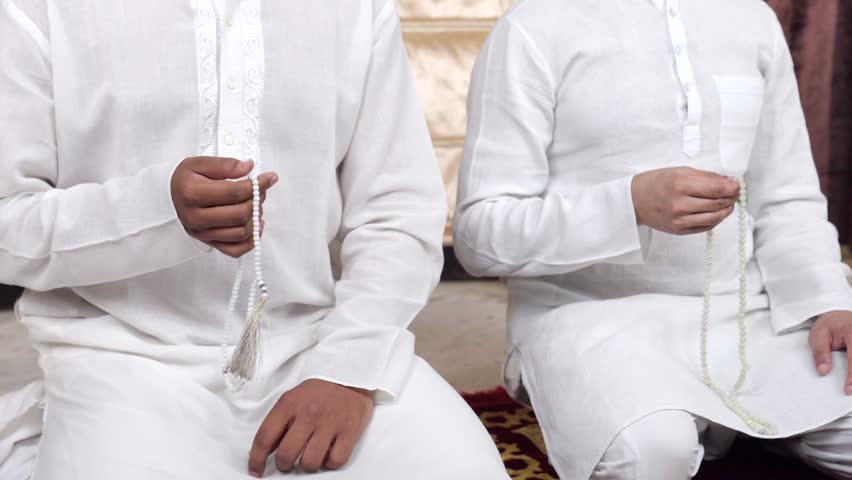 Indian Muslim men praying beads and praying to Allah