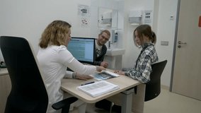Young family talking to the therapist on the medical appointment. Female doctor speaking with the family during medical appointment. Specialist discussing family medical problems on appointment. - Powered by Shutterstock - Get 15% off with code: PIKWIZARD15