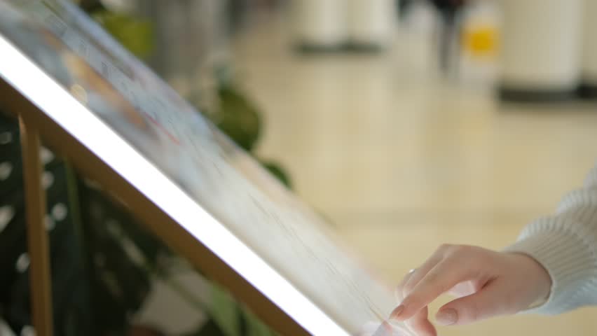 Woman looking for information and store location on digital touch screen in shopping mall 4K Royalty-Free Stock Footage #1100452791