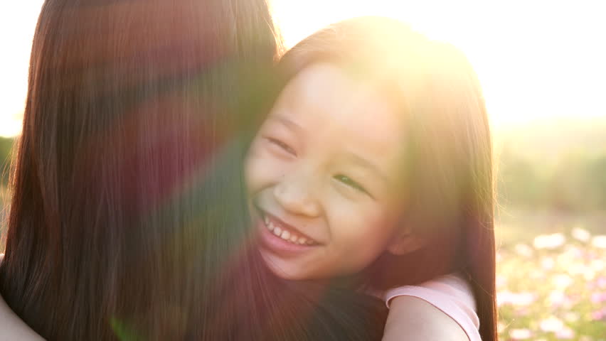 Mothers Day, Happy Family, Valentine Day, Love Concept. Close-up happy Asian child girl embrace or hugging mother, smiling, happiness moment in nature outdoor sunset. Concept of love, happy family | Shutterstock HD Video #1100453399