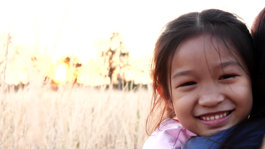 Mothers Day, Happy Family, Valentine Day, Love Concept. Close-up happy Asian child girl embrace or hugging mother, smiling, happiness moment in nature outdoor sunset. Concept of love, happy family | Shutterstock HD Video #1100453401
