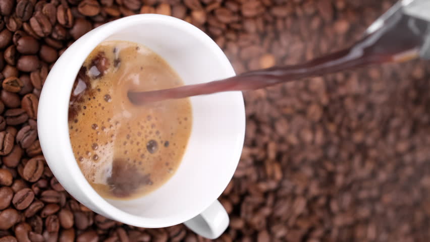 Pouring black coffee in cup from geyser coffee maker. Coffee with froth. Vertical video