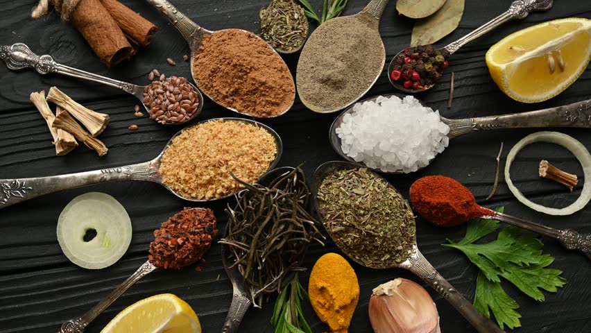 Colorful herbs and spices for cooking. Indian spices. On a black background. Top view