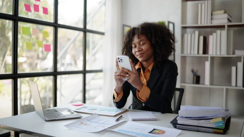 Young business women working and typing on smartphone with happy and smile face on office spec.
