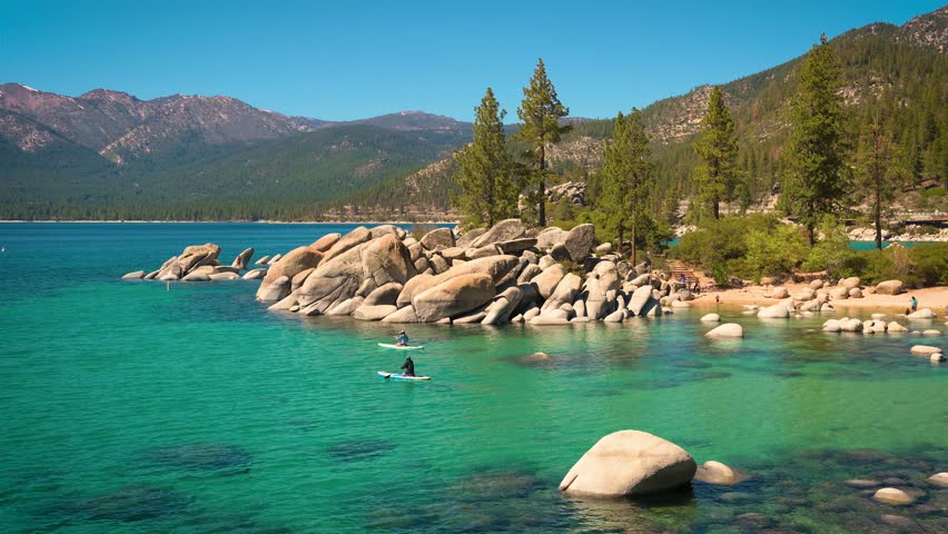 Two Canoes with people floating on the turquoise waters of Lake Tahoe in Sand Harbor Beach, Nevada, USA. 4K UHD video.