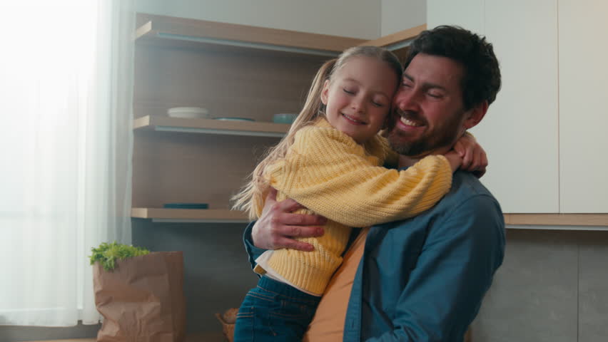 Happy affectionate Caucasian family adult single parent bearded man dad and small kid daughter cuddling hugging at home kitchen. Loving father hug child girl bonding embracing talking, Father's day Royalty-Free Stock Footage #1100458743