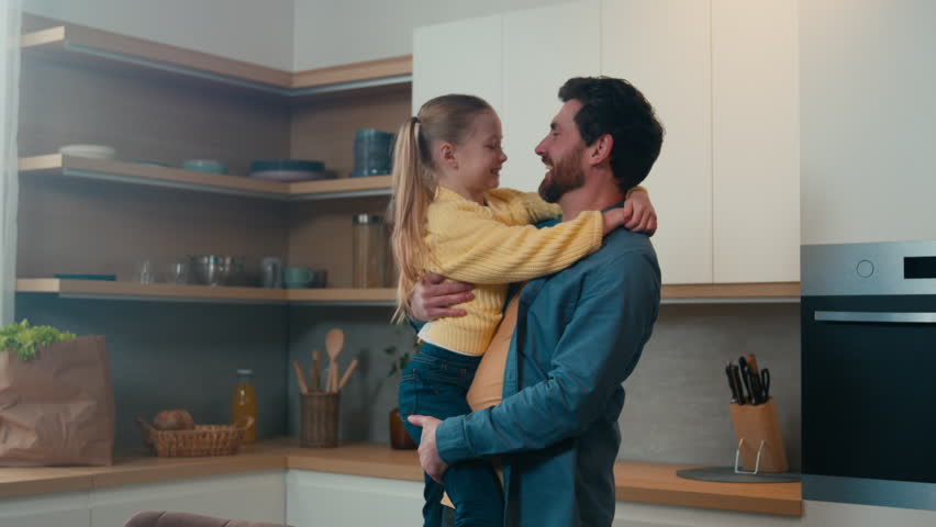 Happy affectionate Caucasian family adult single parent bearded man dad and small kid daughter cuddling hugging at home kitchen. Loving father hug child girl bonding embracing talking, Father's day | Shutterstock HD Video #1100458743