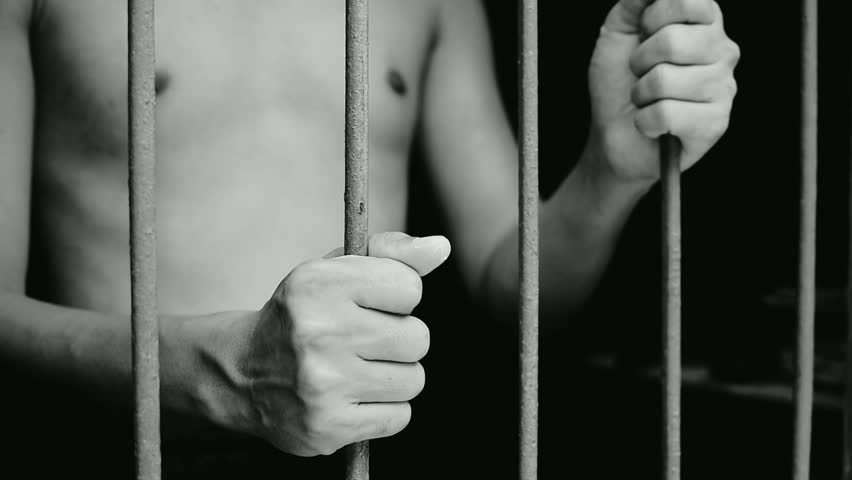 Man hand holding iron and shaking cage in prison on black background Prisoner concept, tragic, miserable, cruel | Shutterstock HD Video #1100460161