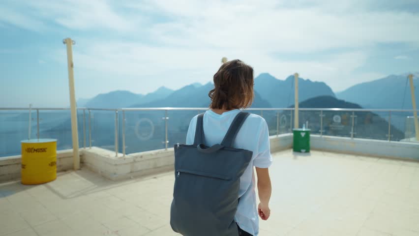 treking camera shot traveler freedom woman with backpack walking at view point on mountain top and enjoying mountains view, summer journey vacation. upper station of cable way in Antalya, Turkey