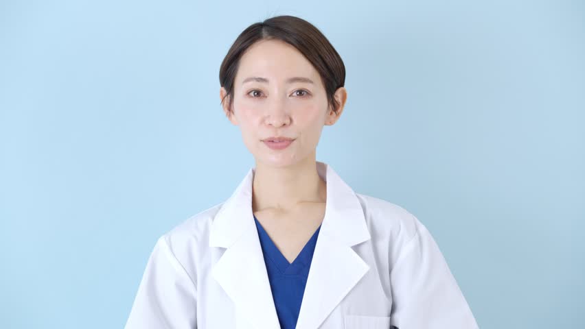 Smiling Asian doctor with blue background Royalty-Free Stock Footage #1100469201