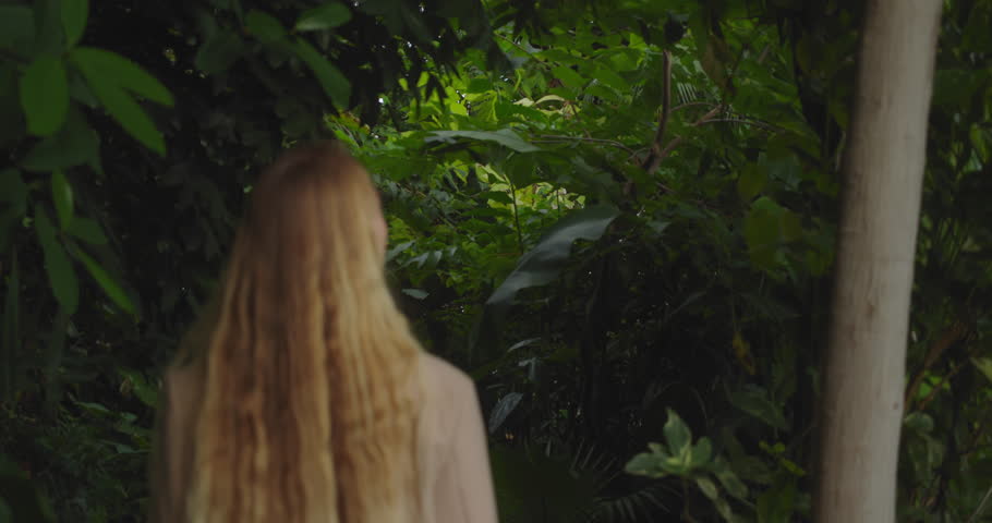 Blond woman in beige coat goes deeper into jungle, getting lost