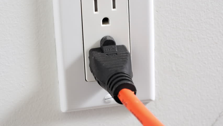 Unplugging an extension cord or appliance power cord from the wall outlet | Shutterstock HD Video #1100472625