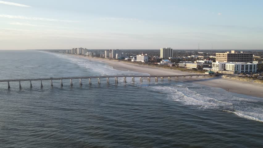 Drone overview of the Jacksonville Beach Fishing Pier during sunrise.