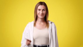 4k slow motion video of one woman asks to call someone over yellow background.