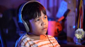 Close up of Boy talks looking to computer monitor screen. Kid wearing headphones using microphone. Online learning, remote education, gaming, podcast. 