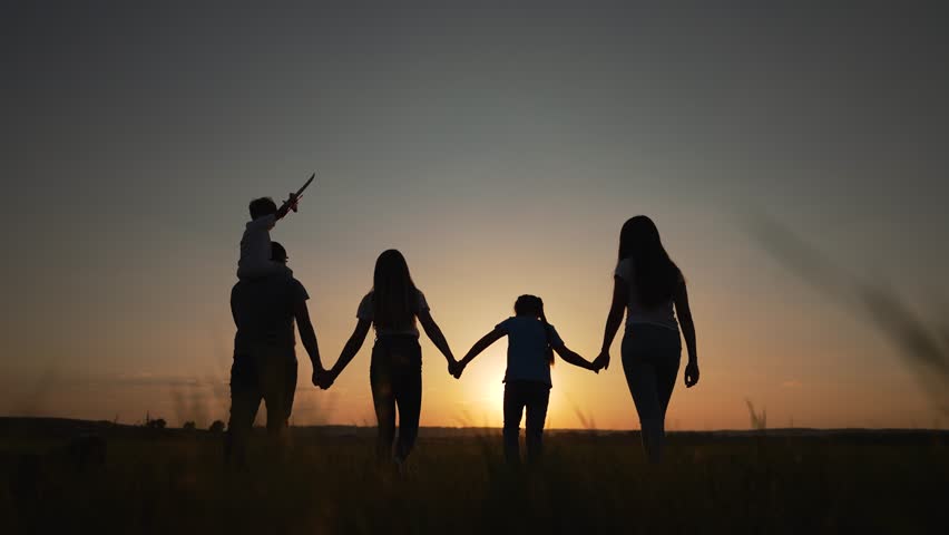 Family outdoors in park at sunset.Silhouette of family walking in park at sunset.Happy father, mother, kids in park. Family lifestyle. Family on walk. Summer lifestyle in nature. father, mother, kids Royalty-Free Stock Footage #1100477607