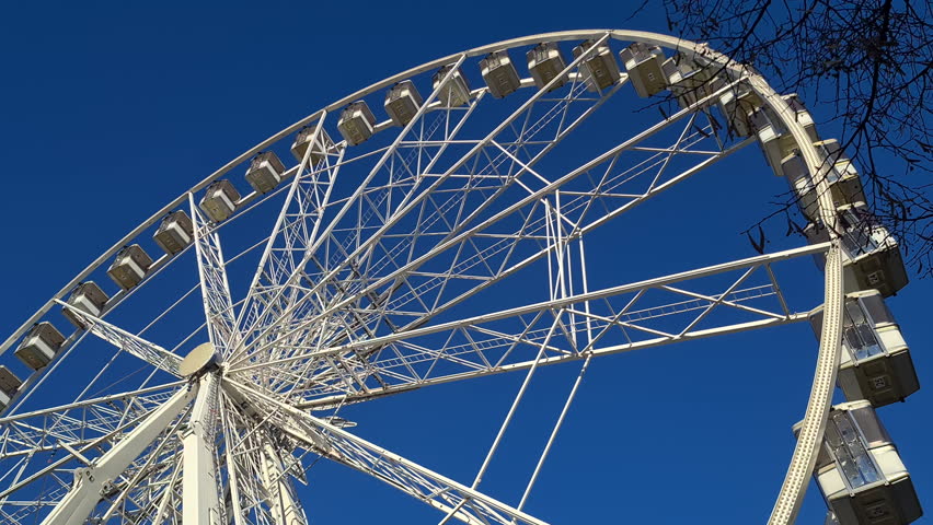 Ferris Wheel Spinning Under Blue Sky on Sunny Day. Budapest Eye, Hungary