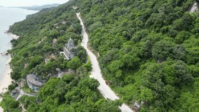 Aerial video of the island of Ko Pha Ngan, Thailand, with moving cars, the beach and the jungle in the background