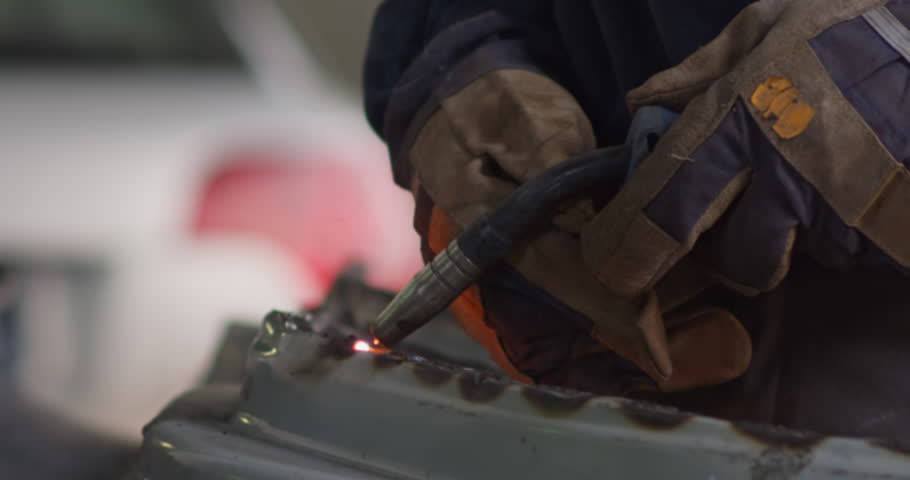 Body shop worker welding car panel | Shutterstock HD Video #1100485795