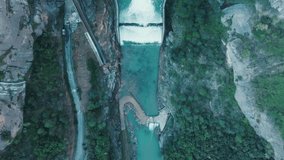 Video of drone views of a water dam in a mountain landscape