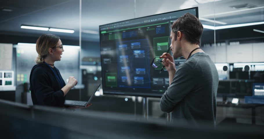 Two Diverse Software Developers Having a Meeting in a Conference Room. Female and Male Tech Industry Engineers Brainstorming Ideas for Their Neural Network Blockchain Startup Royalty-Free Stock Footage #1100488241