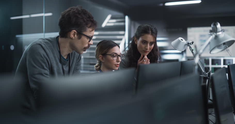 Team of Three Talented Young Software Engineers Use Computer to Discuss a Technological Project in Modern Industrial Office. Group of Male and Female Scientists Work in Research and Development Center Royalty-Free Stock Footage #1100488325