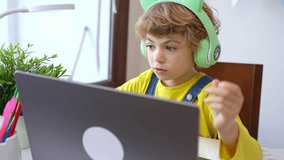 Cute smart caucasian using laptop. Online tutor teaching digital class, web lesson on computer at home. Virtual education. Schoolboy girl studying write exercise doing homework.