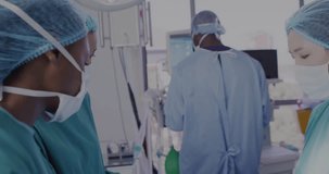 Animation of medical icons and data over diverse female surgeons talking during operation. Medical and healthcare services concept digitally generated video.